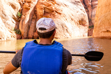 Back of man swimming kayaking in Lake Powell water antelope slot canyon with paddle oar and life jacket vest exploring nature © Kristina Blokhin
