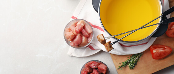 Flat lay composition with fondue pot and meat on light table, space for text. Banner design