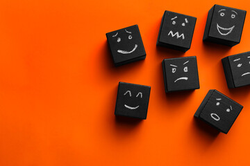 Many cubes with different emotions on orange background, flat lay and space for text. Emotional...