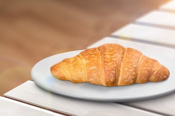 Croissant on a white plate, freshly baked.