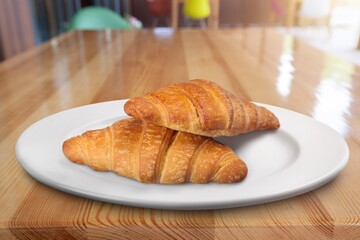 Croissant on a white plate, freshly baked.