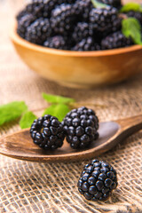 Blackberry close-up on the background of a wooden spoon  with blackberries.