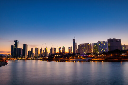 Scenic view of lake and city scape against sky during sunset © Sangoh