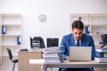 Young businessman employee unhappy with excessive work in the of