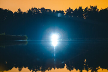 Beautiful night landscape on the lake, a bright lantern illuminates the lake at night