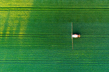 Aerial view of a tractor spraying agricultural fields. spraying herbicides on the field