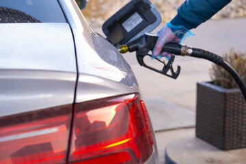 Diesel.Refueling the car.Refueling pistol in the hands of a man in a blue glove.Car at a gas...