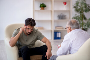 Obraz premium Young man visiting old psychologist
