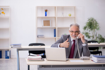 Old male employee working in the office