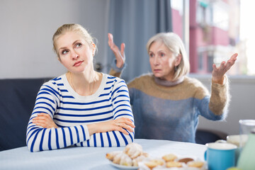Elderly mother is unhappy with her adult daughter during a domestic quarrel