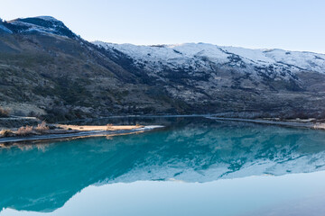 reflejo en el agua de un lago de aguas cristalinas, montaña nevada, con bosques reflejada en el agua de un lago con orillas congeladas 