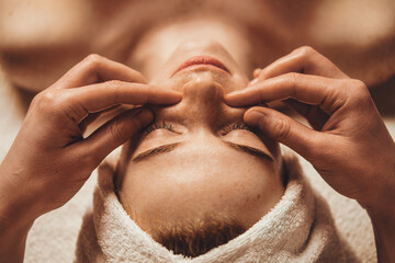 Female patient receiving face massage of detox therapy, at the spa salon. Attractive beautiful...