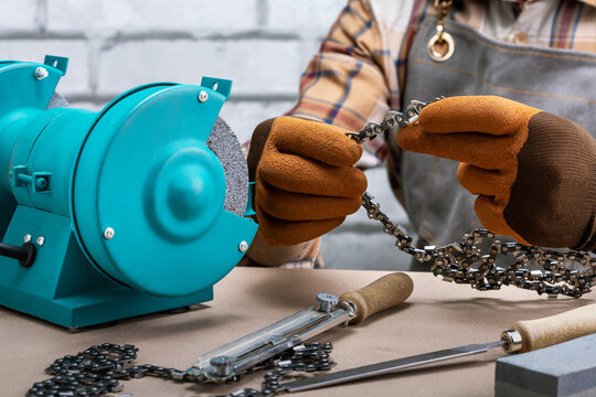 Worker sharpening a chainsaw chain. Man at work.