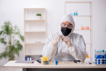 Young male chemist working at the lab during pandemic