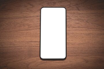 Close up smartphone with an empty white screen on the wooden table at the cafe.