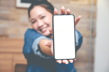 Close up women show a smartphone with an empty white screen at the cafe.