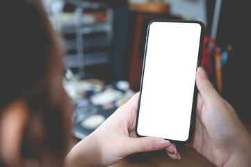 Close up business women using a smartphone with an empty white screen at the office workplace.