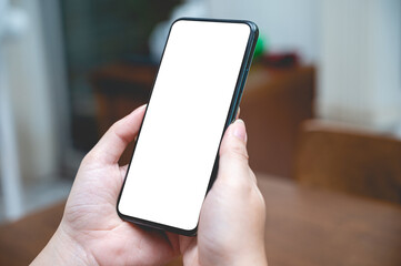 Close up women using a smartphone with an empty white screen at home.