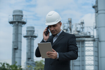 architect talking on phone on power plant bacground.