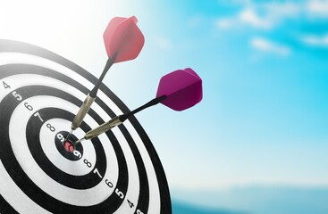 Red dart in center of target over sky background