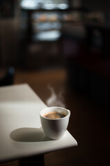 hot coffee on a table with cream being poured into it showing the texture