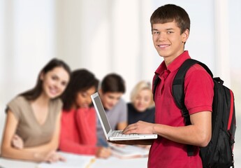 Smiling teacher during computer class at high school and looking at camera.