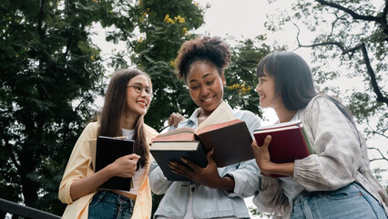 Diversity multi ethnic woman student holding books and looking at natural outdoors at park. Prepare for college and university concept.Informal national education .looking for scholarship opportunity.
