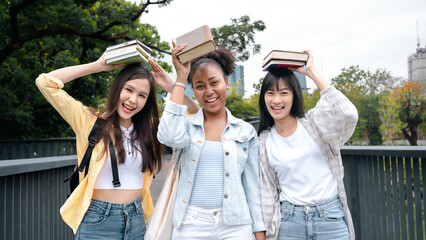 Diversity multi ethnic woman student holding books and looking at natural outdoors at park. Prepare...