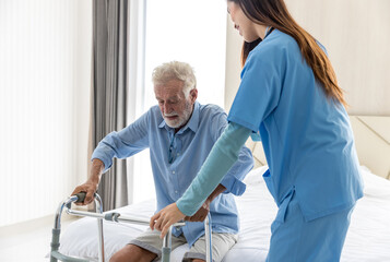Caregiver nurse take care a Senior patient. Nurse helping senior Man hand holding walker trying to...