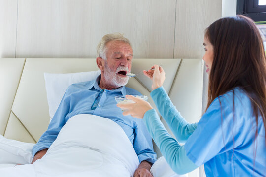 Elderly care feeding an elderly woman at retirement house. Caregiver nurse take care a Senior patient. Nurse helping senior Man feeding food.