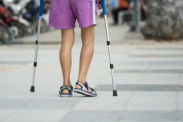 Disable man using crutches to walk for rehab.Patient with leg injury during training with...
