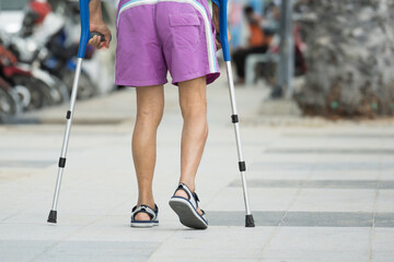 Disable man using crutches to walk for rehab.Patient with leg injury during training with...
