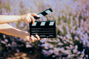 Hand Holding a Film Slate in front of a Lavender Field. Film maker producing a commercial in floral...