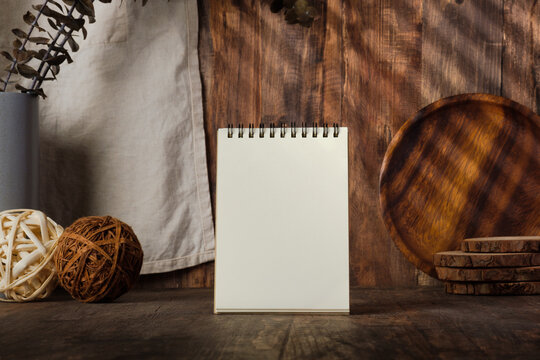 blank notebook recipe with kitchenware on wood table with sunlight