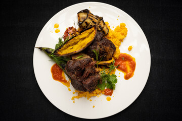 fried lamb chops with sweet potato, vegetables and different colored sauces