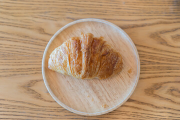 French croissant on the plate on wooden table