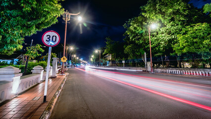 beautiful lit night street The district in front of the school has a traffic sign warning to reduce speed. Nan Thailand
