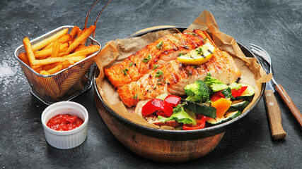 Salmon steak with vegetables on dark background.