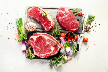 Variety of raw beef meat steaks for grilling.