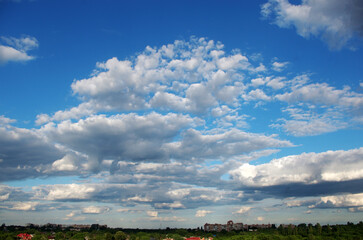 A bottomless sky with cumulus clouds and a summer landscape. Shot with a wide-angle lens.