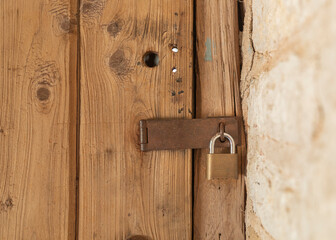 Wooden antique and rustic lock  door under old construction.