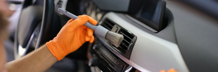 Hands in gloves with a dust brush, detailing