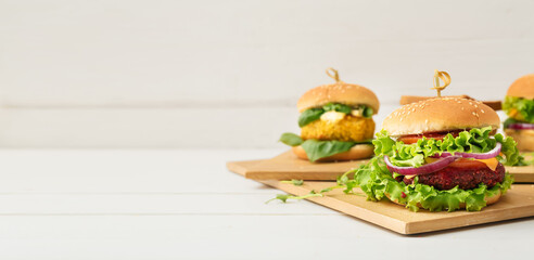 Different tasty vegetarian burgers on table. Banner for design