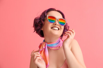 Beautiful young woman with violet hair and rainbow sunglasses on pink background. LGBT concept