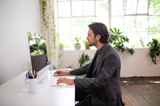 Side view of a man working on a computer in an office