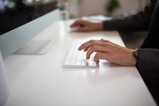 Close-up shot of man's hands typing on a keyboard