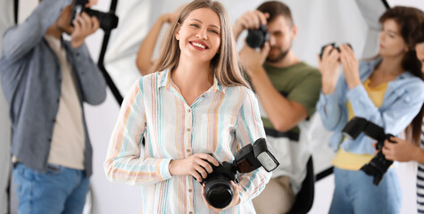 Portrait of pretty female photographer in studio