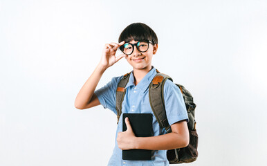 Portrait Photo of mix race boy student moving his black glasses while holding notebooks or lecture books with gray backpacks. Preteen child smiles and looks at the camera. Education Concept