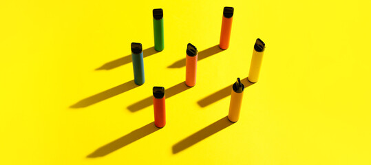 Modern electronic cigarettes on yellow background