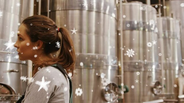 Animation of stars and snowflakes over caucsasian female brewery worker